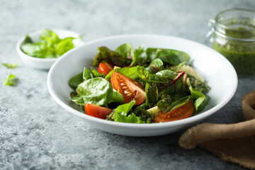 Healthy green salad with tomatoes and pesto