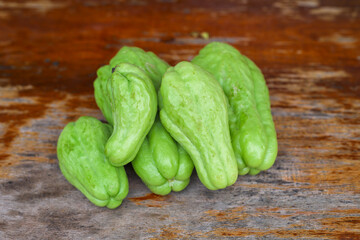 Fresh chayote fruits (Sechium edule) on wooden table.