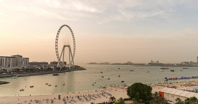Sunset over Bluewaters island with modern architecture and ferris wheel aerial timelapse close up view. New leisure and residential area near Dubai marina and JBR.