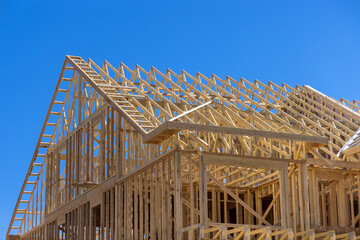 Framing wood beams of wooden building with new stick built home under construction