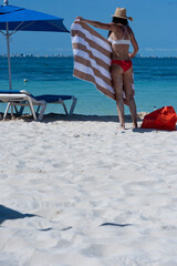 Rearview shot of a girl in a bikini with a beach towel on the tropical island of Isla Mujeres in Mexico