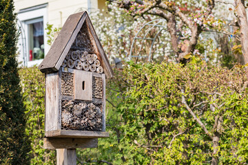 Small wooden house hotel to attract insects set in the garden on a sunny day