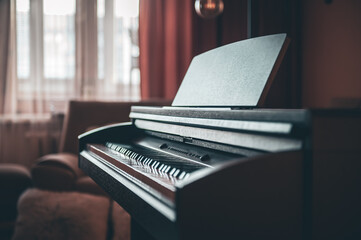 Electronic piano in the interior of the room on a blurred background.