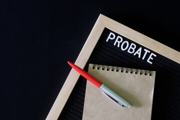 Inscription probate on a black felt board next to a notepad and fountain pen. The concept of...