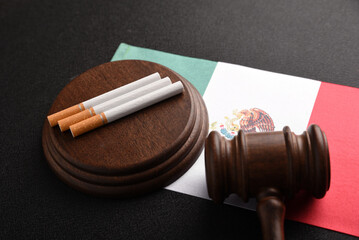 Cigarettes and Judge Wooden Gavel on Mexico flag background. Problems with law. Tobacco law