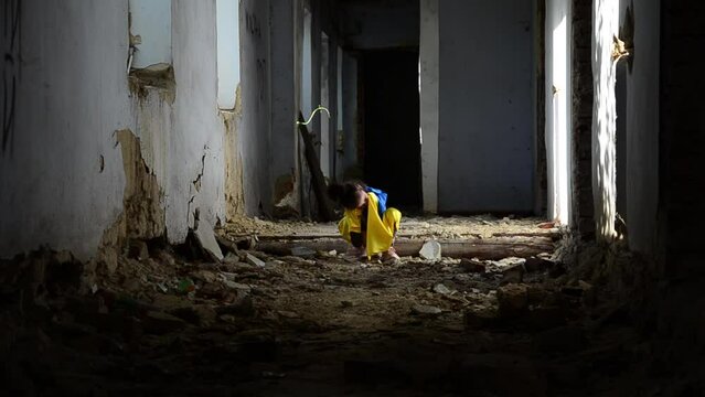 War in Ukraine. A child walks through a collapsed building in Ukraine. Consequences of the war in Ukraine. Children against war. Peace concept. Destroyed Ukrainian buildings. A child in a bomb shelter