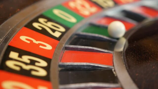 Ball on wooden french roulette table in casino. Wheel spinning, turning or rotating. Odd and even numbers, black, red and zero sectors. Bets in game of chance. Money playing, gambling or risky betting