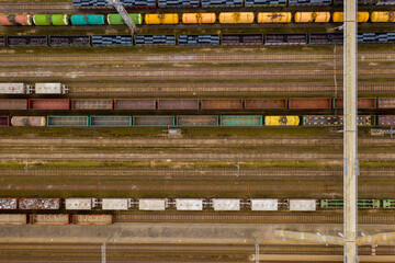 Aerial view of colorful freight trains with goods on the railway station.