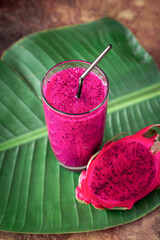 Fresh smoothies from a dragon fruit  in glass.  juice and fresh pitahaya on a tropical background