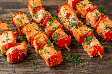 Close up of grilled salmon kebab. Barbecue salmon skewers on wooden cutting board