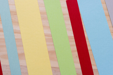 yellow, green, red, and blue paper strips on a wooden surface