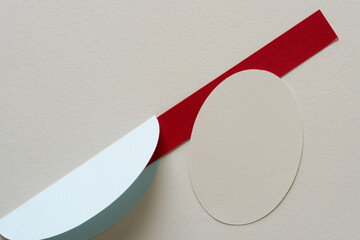 two oval shapes (one folded) and a red paper stripe