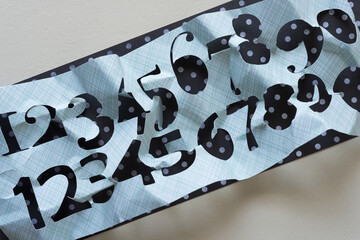 crumpled paper stencil (with numbers) on a backdrop of polka dots