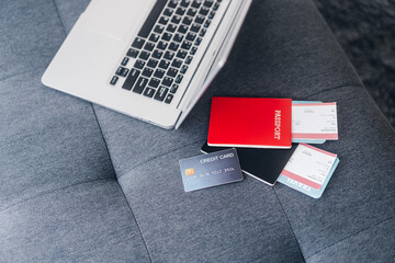 Credit card place with passport and airplane ticket boarding pass and laptop