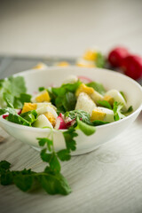 Fresh spring salad with fresh lettuce leaves, radishes, boiled eggs in a bowl