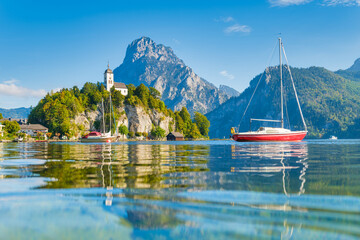 A yacht against the backdrop of mountains and an old castle in Switzerland. A popular place to travel and relax.