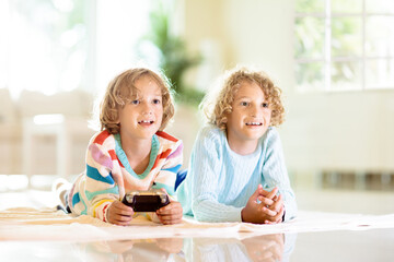 Kids play video game. Children with controller.
