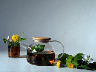 Herbal tea in a teapot with herbs and flowers. Benefits of herbal tea.