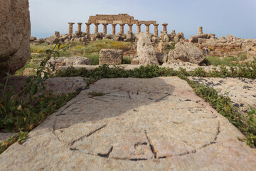 Castelvetrano. Trapani. Punti cardinali scolpiti su pietra sullo sfondo del Tempio C dedicato ad Apollo - obrazy, fototapety, plakaty