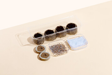 Round Peat briquettes for growing seedlings dry, wet on a beige background and radish seeds in container. Isometric.