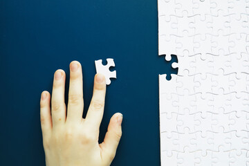 IQ development. Intellectual puzzles. The puzzle is empty. Brain training hand puts puzzle pieces together.