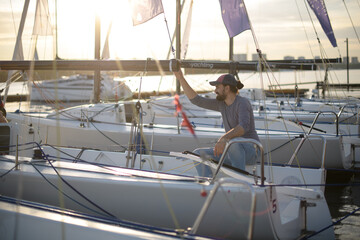 Fototapeta premium Preparation for the regatta at the yachting school at the marina with sailing yachts.