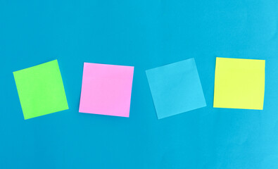 four color blank note paper on blue paper background