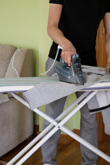 Young man ironing clothes