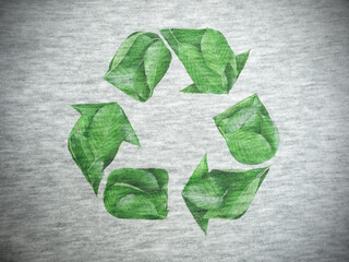 The sign of recycling created by green leaves is printed on cotton fabric