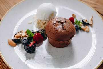 There is a white plate of the tasty dessert on the wooden table.