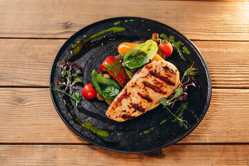 There are a dark plate with a tasty dish.