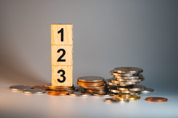 Wooden block number with stack coins using as business development and financial concept