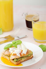 Breakfast with a sandwich with poached egg and avocado