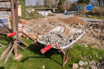 Wheelbarrow containing building rubble at a building site.
