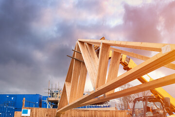 Forklift shifting roof trusses on new residential housing development construction site