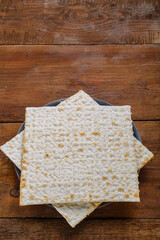 Matzah in a plate on a wooden table save a place.