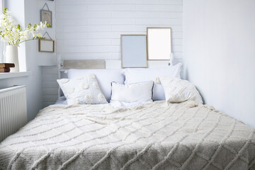 The bedroom has a cozy bed with light linens, knitted plaid, home decor