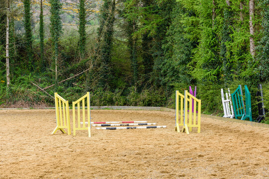 Horse jumping poles and stands on an outdoor paddock.