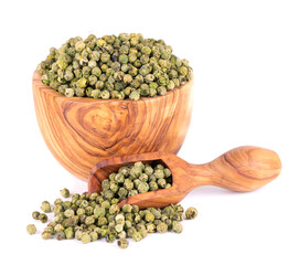 Green peppercorns in olive bowl and spoon, isolated on white background. Dry green pepper grain....