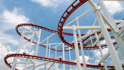 red roller coaster in a amusement park in sunny day