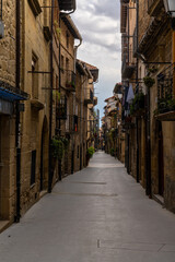 Fototapeta na wymiar narrow picturesque street with brown stone buildings in the historic city center of Laguardia in La Rioja