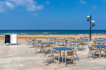 beachfront restaurant with empty chairs and tables and menu boards and no customers
