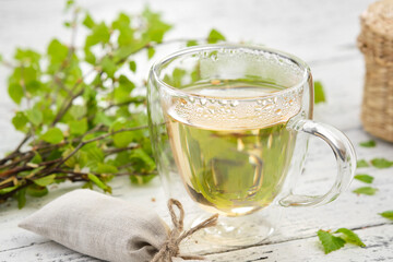Healthy herbal tea cup, twigs of Birch tree with leaves. Alternative herbal medicine.