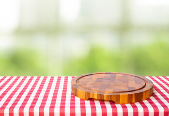 Chopping board on table and blur green bokeh background.
