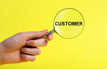 Customer research. Hand with magnifier on yellow background. Analysis and understanding of clients,...