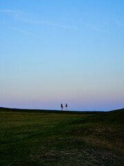 Obraz na płótnie Canvas Couple on the horizon far away and she is standing on one leg