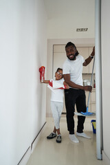 Adult african american man with daughter are cleaning the room