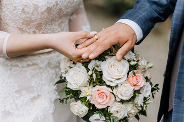 Hands, fingers with gold rings of the bride and groom close-up at the wedding ceremony against the...
