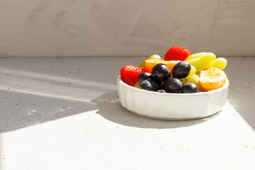 Fresh fruits on a plate in bright sunlight. copy space