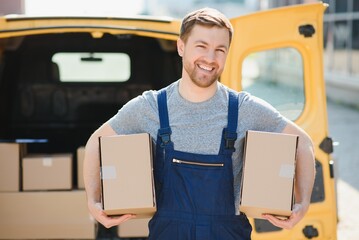 The courier brought the delivery of the box to the client. Courier service employee in uniform.